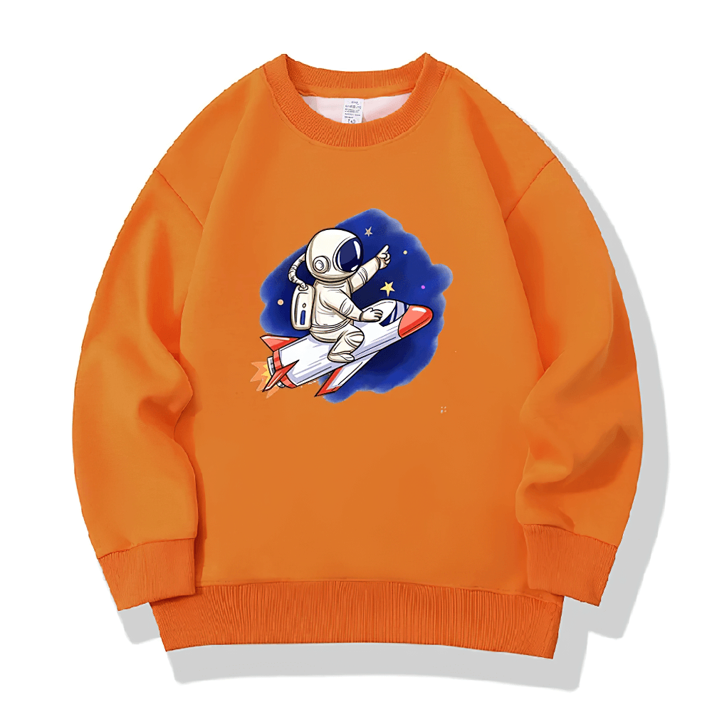Orange kids sweatshirt with astronaut on a rocket, surrounded by stars, perfect for space-themed fun. Available in multiple colors.